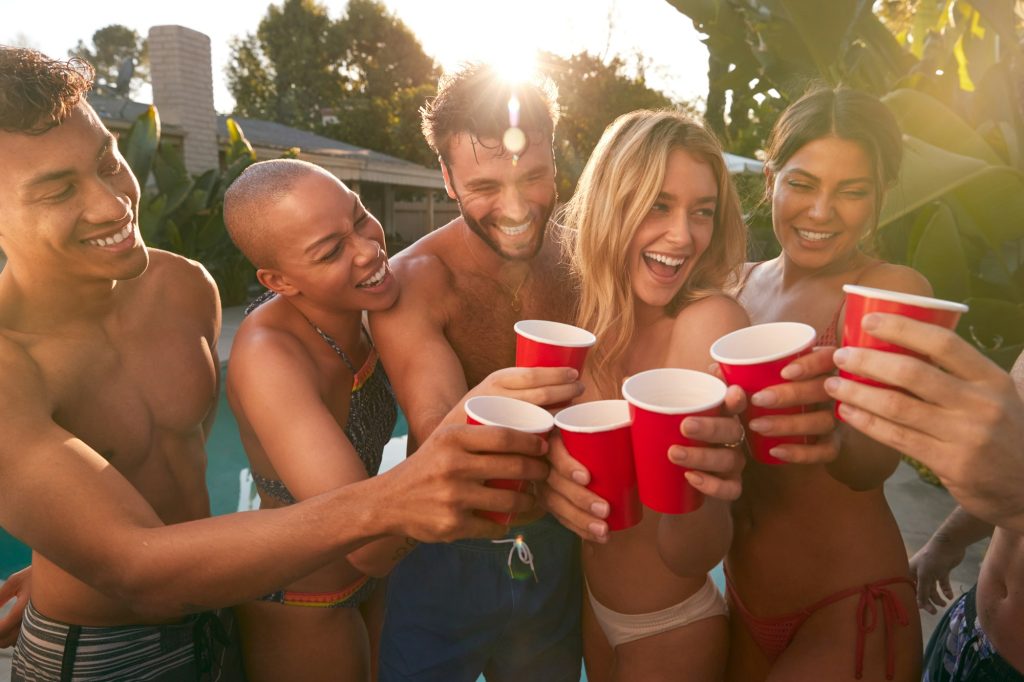 Group Of Smiling Friends Outdoors Making A Toast With Beer And Enjoying Summer Pool Party Group Of Smiling Friends Outdoors Making A Toast With Beer And Enjoying Summer Pool Party